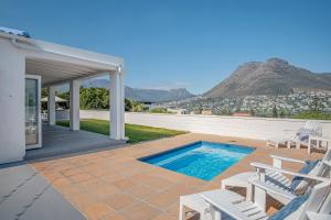 uma villa com uma piscina e um pátio em Cockleshells Beach Cottage na Cidade do Cabo