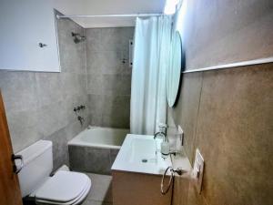 een badkamer met een toilet, een wastafel en een bad bij Cedro Azul in La Cumbre