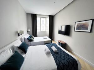 pokój hotelowy z 2 łóżkami i telewizorem z płaskim ekranem w obiekcie 141 - Urban Beautiful Flat near Champs-Elysees w Paryżu