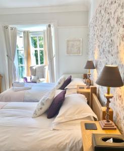 a bedroom with two beds and a table with a lamp at Sheriff Lodge in Matlock