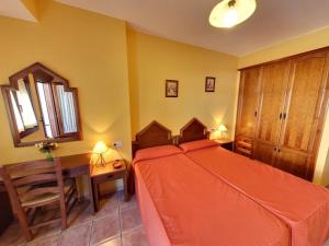 een slaapkamer met een bed, een tafel en een stoel bij Hotel Rural Pepe Alvarez in Trevélez