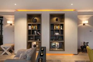 una sala de estar con una pared con estanterías en Knightsbridge & Chelsea Lux apartments en Londres