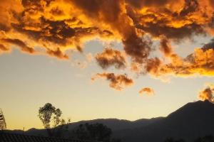 um pôr-do-sol com um monte de nuvens no céu em PENEDO ACONCHEGO LOFT: VISTA, CONFORTO E NATUREZA! em Penedo