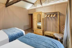 a bedroom with two beds and a cabinet in it at Host & Stay - Hecklers Cottage, Barnard Castle in Barnard Castle