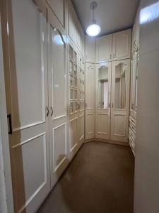 an empty closet with white cabinets and a light at Suíte de Luxo no centro, com hidromassagem e closet in Sinop