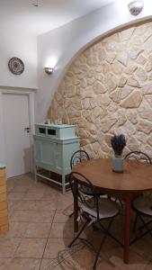 cocina con mesa y pared de piedra en Casa Curu en Sciacca