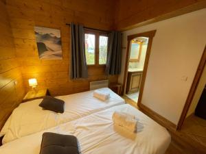 a bedroom with two beds in a log cabin at Chalet Les Trappeurs in Les Carroz d'Araches