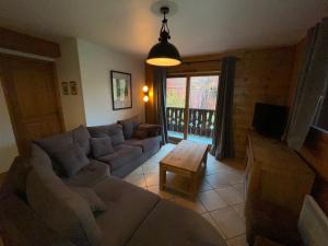 a living room with a couch and a table at Chalet Les Trappeurs in Les Carroz d'Araches