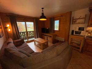 uma sala de estar com um sofá e uma mesa em Chalet Les Trappeurs em Les Carroz d'Arâches