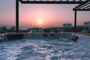 a jacuzzi tub with the sunset in the background at Vivo Mare Beachfront-Seaview Villas in Ayia Napa