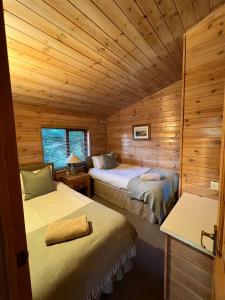 a room with two beds in a log cabin at Mallard Lodge - Arscott Lodges in Shrewsbury
