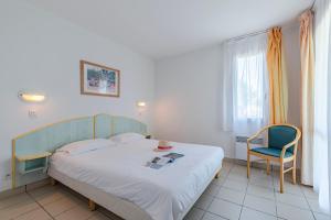 a small bedroom with a bed and a chair at Azureva Fouras in Fouras