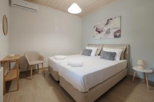 Habitación blanca con cama y escritorio en House Belelis, en Afionas