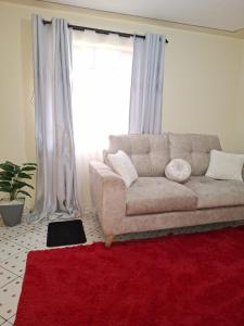 ein Wohnzimmer mit einem Sofa und einem roten Teppich in der Unterkunft The Sunset in Nairobi