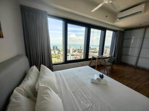 a bedroom with a large white bed with a large window at LS Tropicana 218*Sea View*1BR*Georgetown*King Bed in George Town