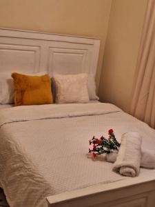 ein weißes Bett mit Blumen und Handtüchern darauf in der Unterkunft The Sunset in Nairobi