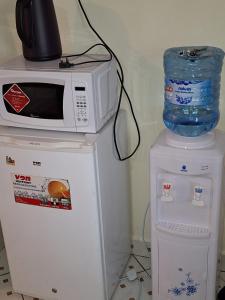 eine Mikrowelle auf einem kleinen Kühlschrank in der Unterkunft The Sunset in Nairobi