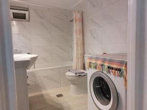 een badkamer met een wasmachine en een wastafel bij Grammatoula Apartment in Nikiana