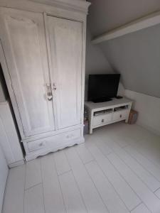 um quarto com um armário branco e uma televisão em Villa Esperanza les2Pat -Disney -JO nautiques vaires em Lagny