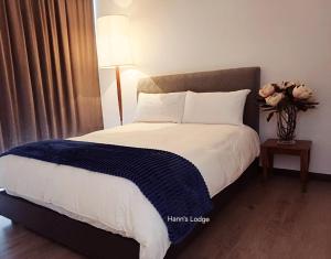 a bedroom with a large bed with a vase of flowers at Hann's Lodge in Putrajaya