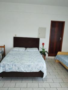 a bedroom with a large bed with a wooden headboard at Apartamento Encantador Penha Beto Carrero World in Penha