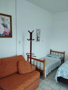a living room with a couch and a cross on the wall at Apartamento Encantador Penha Beto Carrero World in Penha