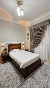 a bedroom with a large bed and a window at Al Saraya Hotel Bani Sweif in Banī ‘Aţīyah
