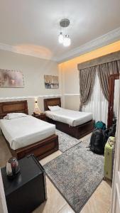 a hotel room with two beds and a table at Al Saraya Hotel Bani Sweif in Banī ‘Aţīyah