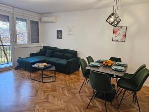 a living room with a blue couch and a table at Apartman Laura in Karlovac
