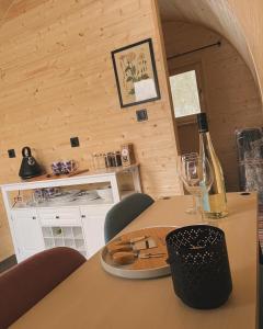 Gościn nad Drawą Glamping في Drawno: طاولة مع زجاجة من النبيذ وكأس