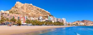 een uitzicht op een strand met een berg op de achtergrond bij Loft de piedra en centro histórico - Casco Antiguo in Alicante