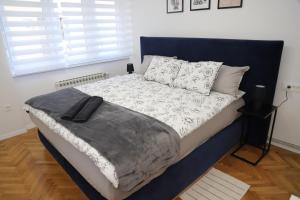 卡爾洛瓦茨的住宿－Apartman Laura，一间卧室配有一张带黑白色棉被的床