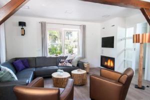a living room with a couch and a fireplace at Familiehuis De Erica - 12 p in Otterlo