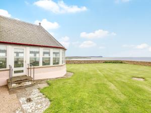 uma casa com um relvado junto ao oceano em 3 Bed in John O Groats CA337 em Mey