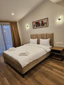 una camera da letto con un grande letto con lenzuola bianche di Hotel Avenue 30 a Yerevan