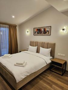 a bedroom with a large bed with two towels on it at Hotel Avenue 30 in Yerevan