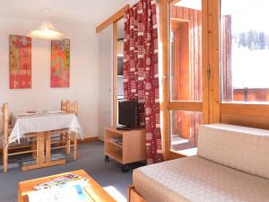 a room with a bed and a table and a window at Studio Plagne Bellecôte, 1 pièce, 4 personnes - FR-1-181-2368 in La Plagne Tarentaise