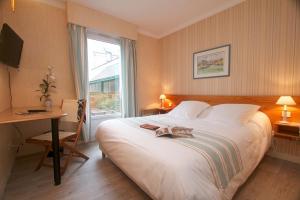 a bedroom with a bed and a desk and a window at Hotel Sully in Nogent-le-Rotrou +19 photos
