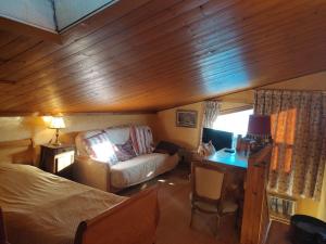 1 dormitorio con cama, escritorio y sofá en Le Montagnard en Demi-Quartier