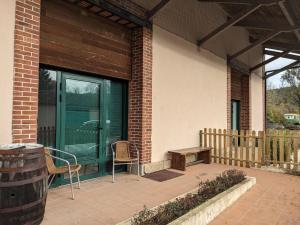 un patio con una puerta verde y un banco de madera en Le METROPOLITAIN, en Laniscat