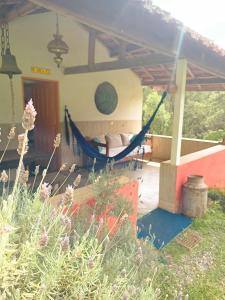 a hammock on the porch of a house at Casa Morango Gonçalves in Gonçalves