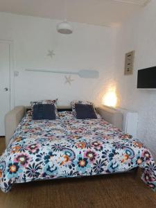 a bedroom with a large bed with a floral bedspread at Le Bon Séjour, studio à 2 pas du Futuroscope in Chasseneuil-du-Poitou