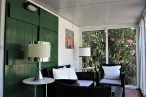 a room with a green wall with chairs and a table at Residence Les Oliviers in Porto Azzurro