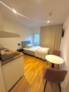Zimmer mit einem Bett und einem Tisch sowie einer Küche in der Unterkunft Hotell By Bostadsagenturen in Stockholm