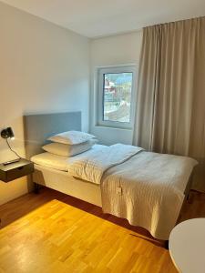 Schlafzimmer mit einem großen Bett und einem Fenster in der Unterkunft Hotell By Bostadsagenturen in Stockholm