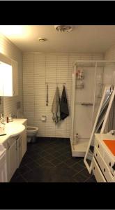uma casa de banho com um chuveiro, um WC e um lavatório. em Tromsø em Tromsø