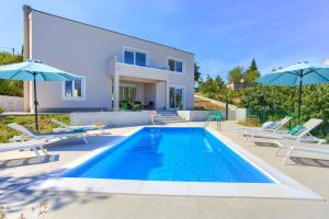 a villa with a swimming pool and a house at Villa Olivia in Vrh