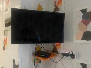 TV de pantalla plana colgada en la pared en G Apartment, en Tiflis