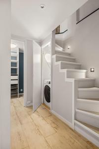Schody w białym pokoju z pralką w obiekcie 100m to Bryggen I Lux Feeling & Private Patio w Bergen
