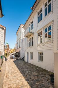 brukowana ulica przed białym budynkiem w obiekcie 100m to Bryggen I Lux Feeling & Private Patio w Bergen